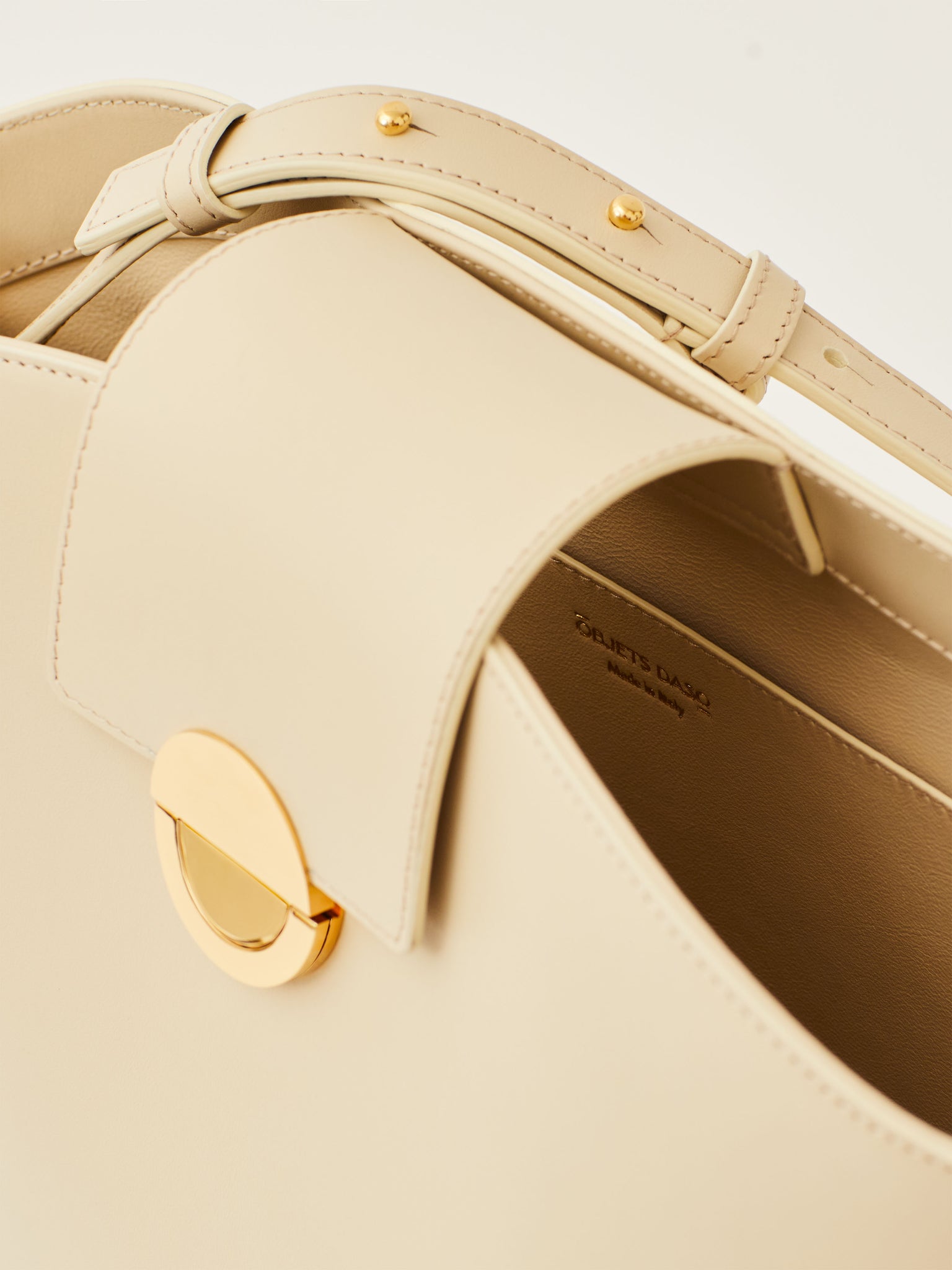 Objets Daso Ivory Leather Vivian Handbag: Close-up of Gold Signature Lock and Interior Pocket